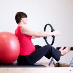 woman in red shirt sitting on fitness equipment