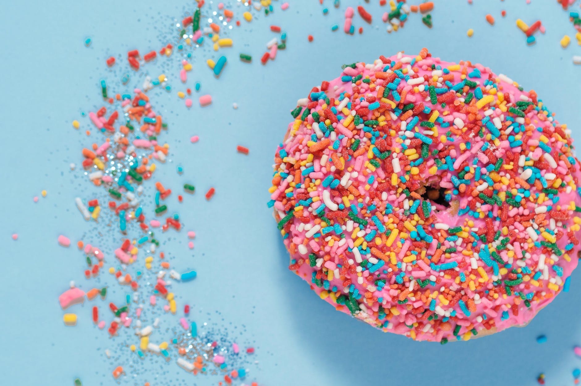 colorful donut with sprinkles on blue surface
