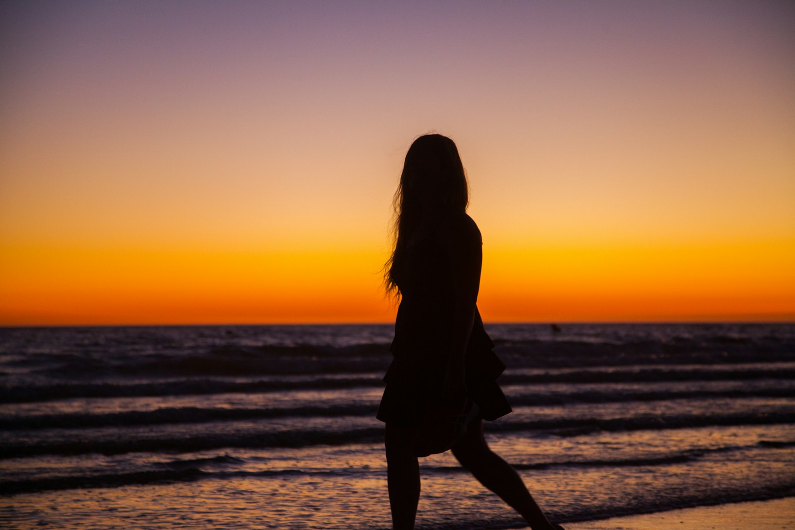 Photo by Olga Guryanova silhouette photography of woman walking on seashore